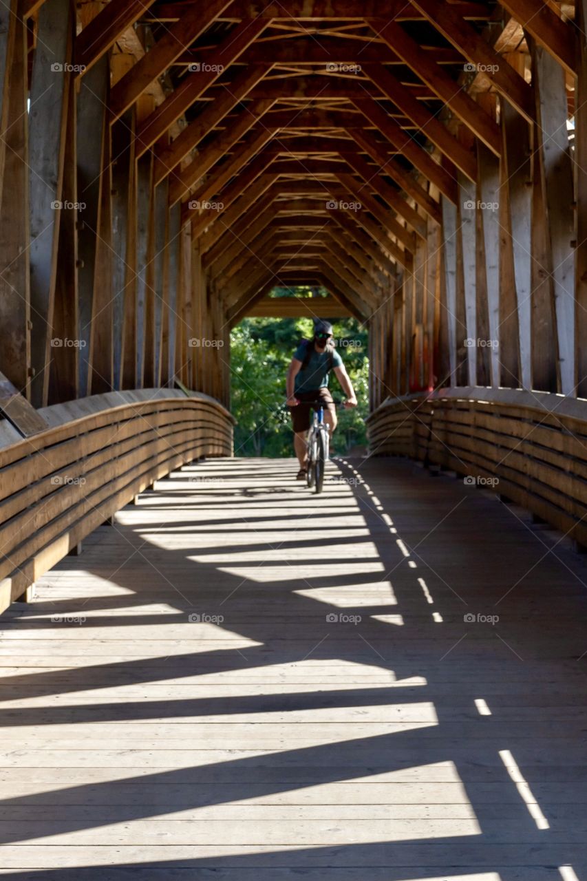 Biking through dimly lit wooden tunnel 