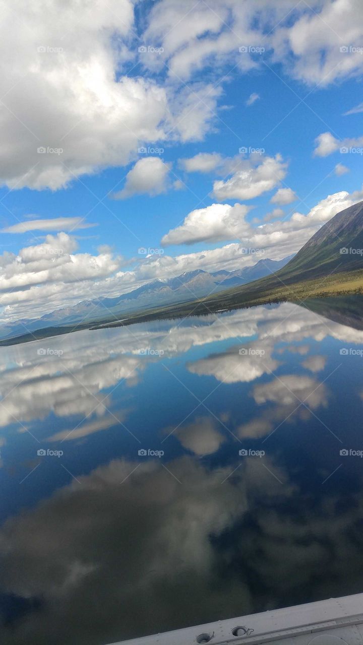 Beautiful mirror image of the sky on a Alaskan lake in the early summer.