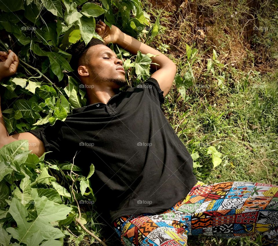 Man lying on foliage thinking or resting 
