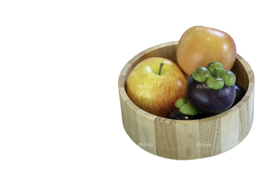 Isolated Mangosteen and apple made from plastic in wood plate on a white background with clipping path.