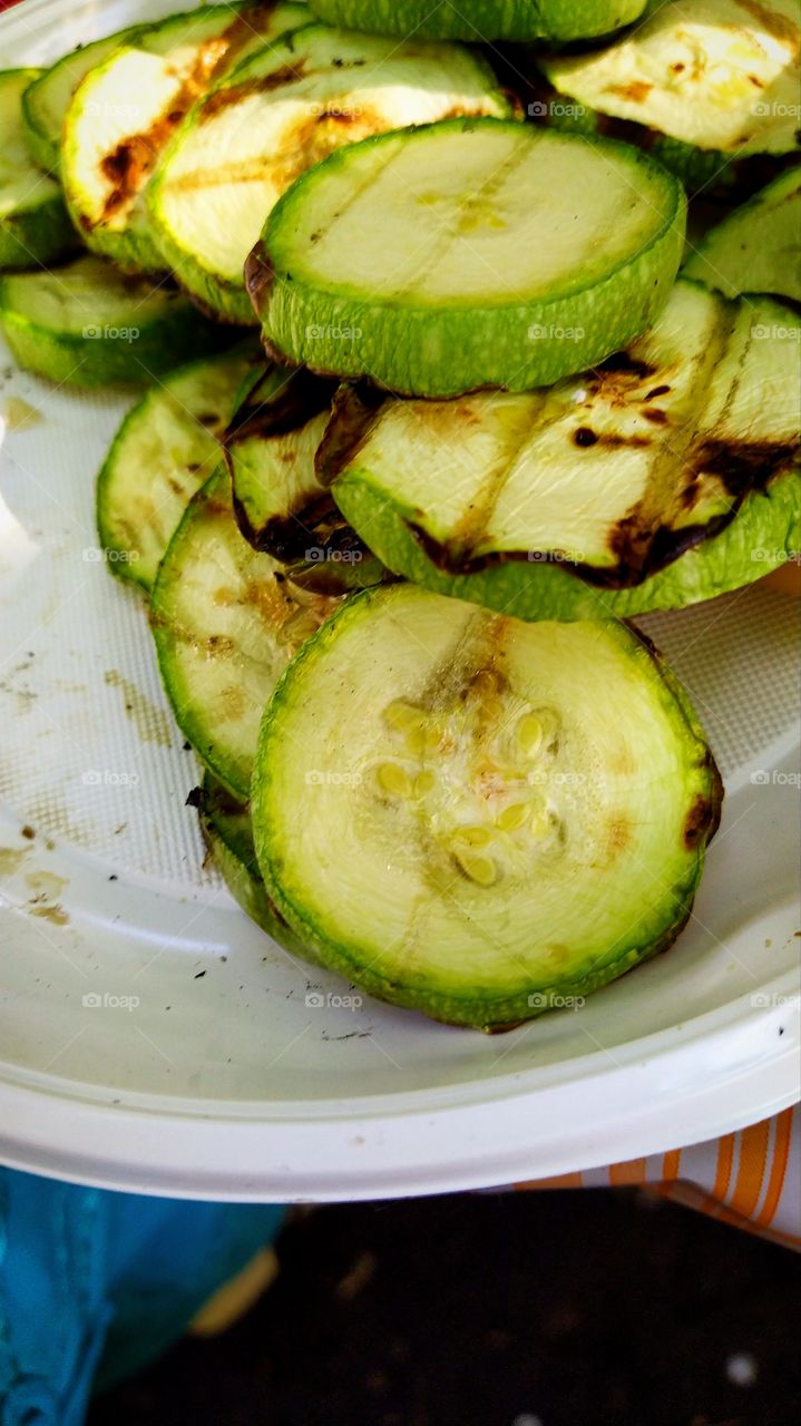 Grilled zucchini in the form of rings in a plastic plate