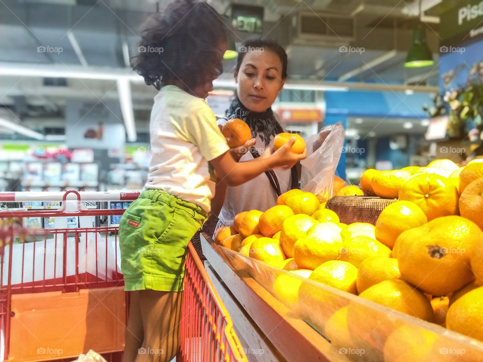 discussion between motherboard and her curly hair daughter about choosing which orange is better.