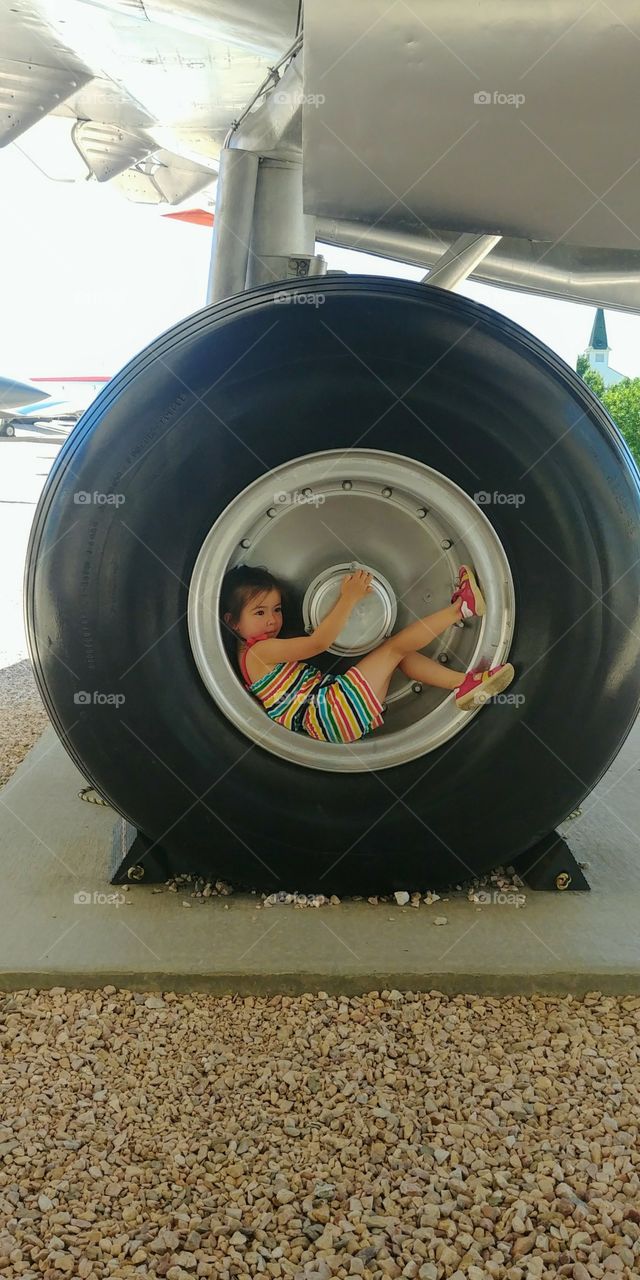young child in an air plane wheel