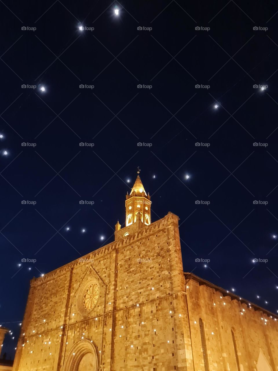 night photo of ancient cathedral illuminated with lots of lights