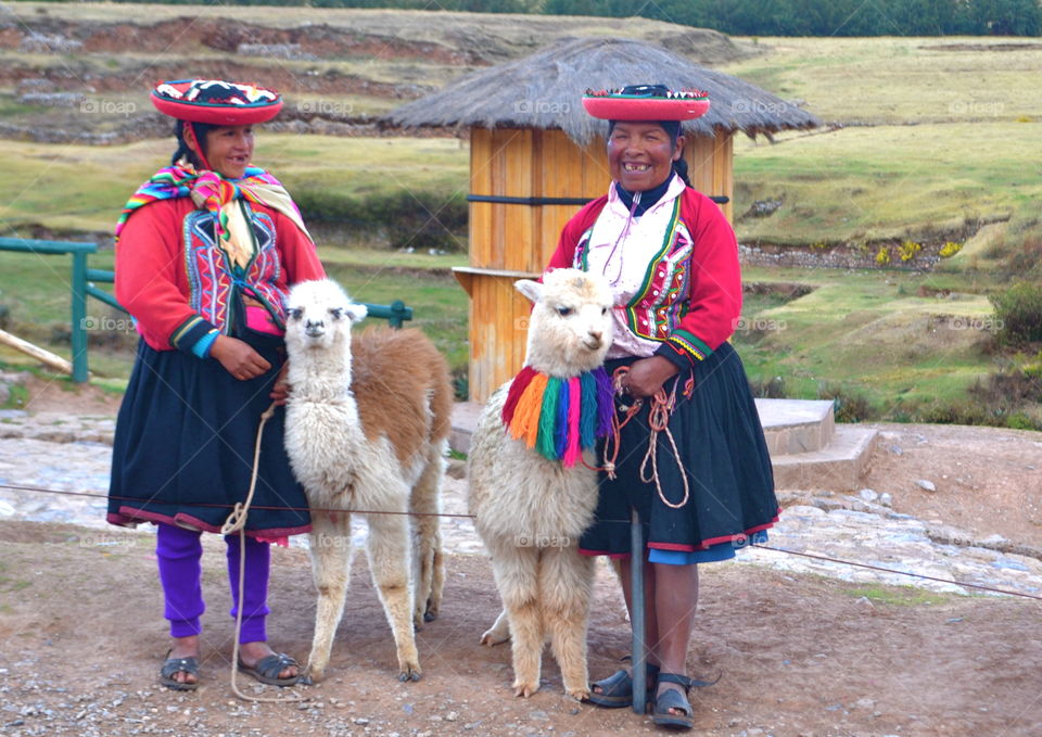 Peruvian Women. Peruvian women vested in colorful attire pose before tourists in Cusco, Peru
