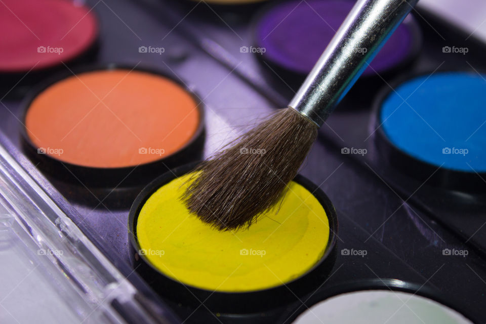 paint brush on yellow waterpaint