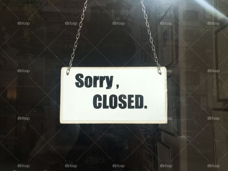 Closed sign on front door of a shop