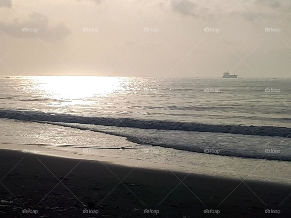 the view of the beach in the morning with amazing reflections of light, the calm water is very suitable for surfing