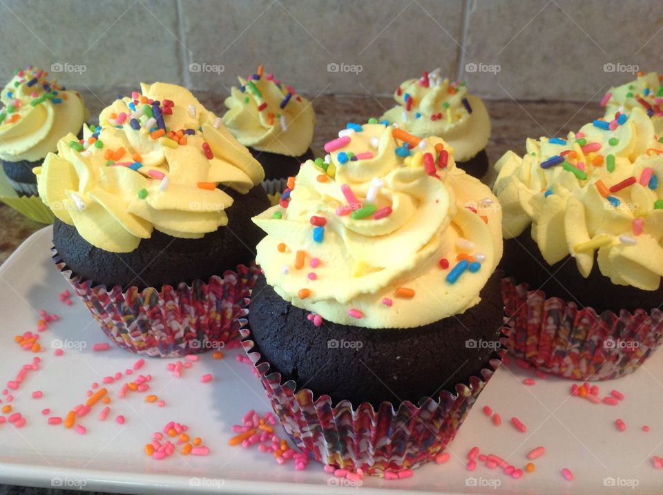 Chocolate cupcakes with rainbow sprinkles.