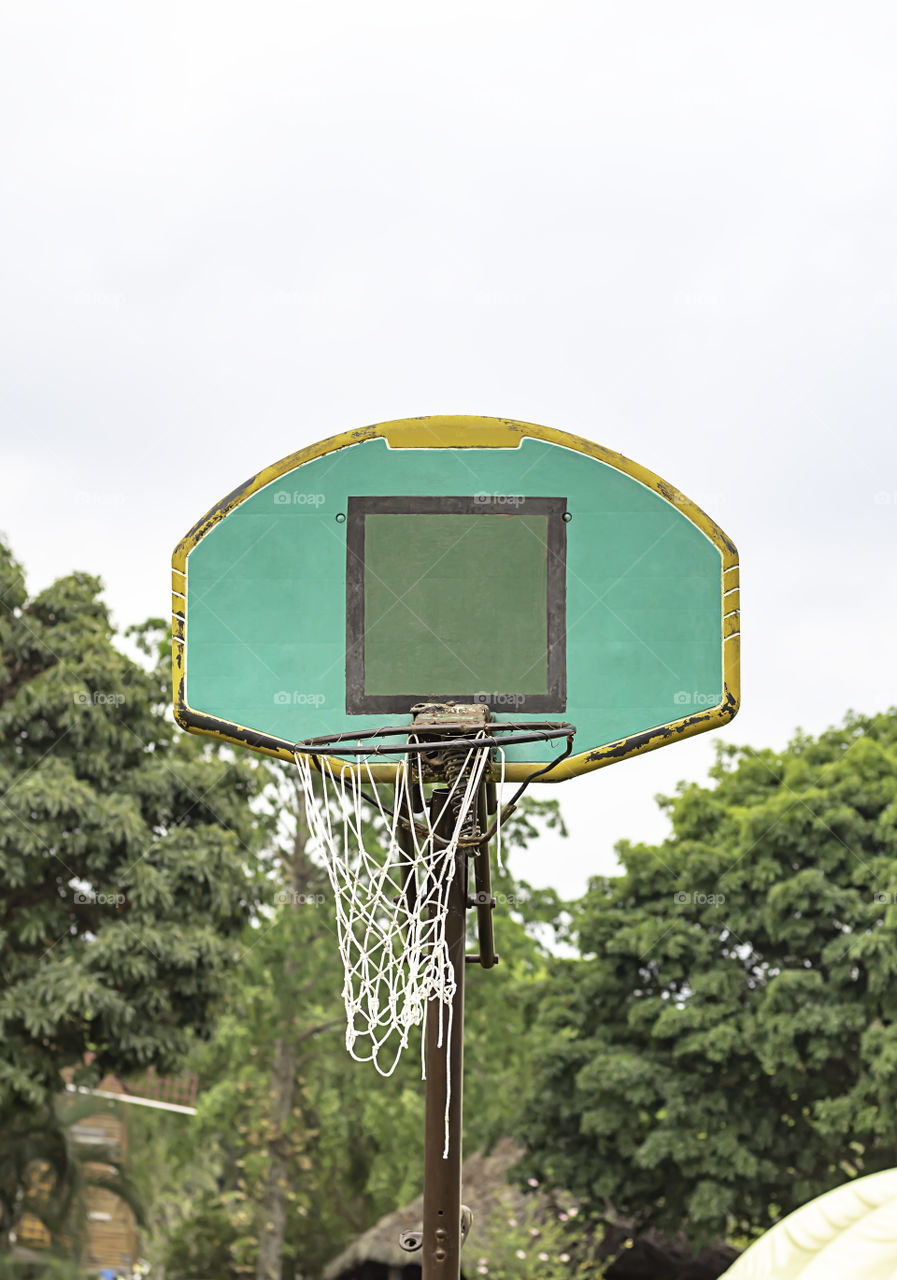 Broken basketball hoop Repair work temporarily background blurry tree and sky.