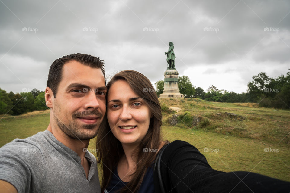 Couple taking selfie in front of statue