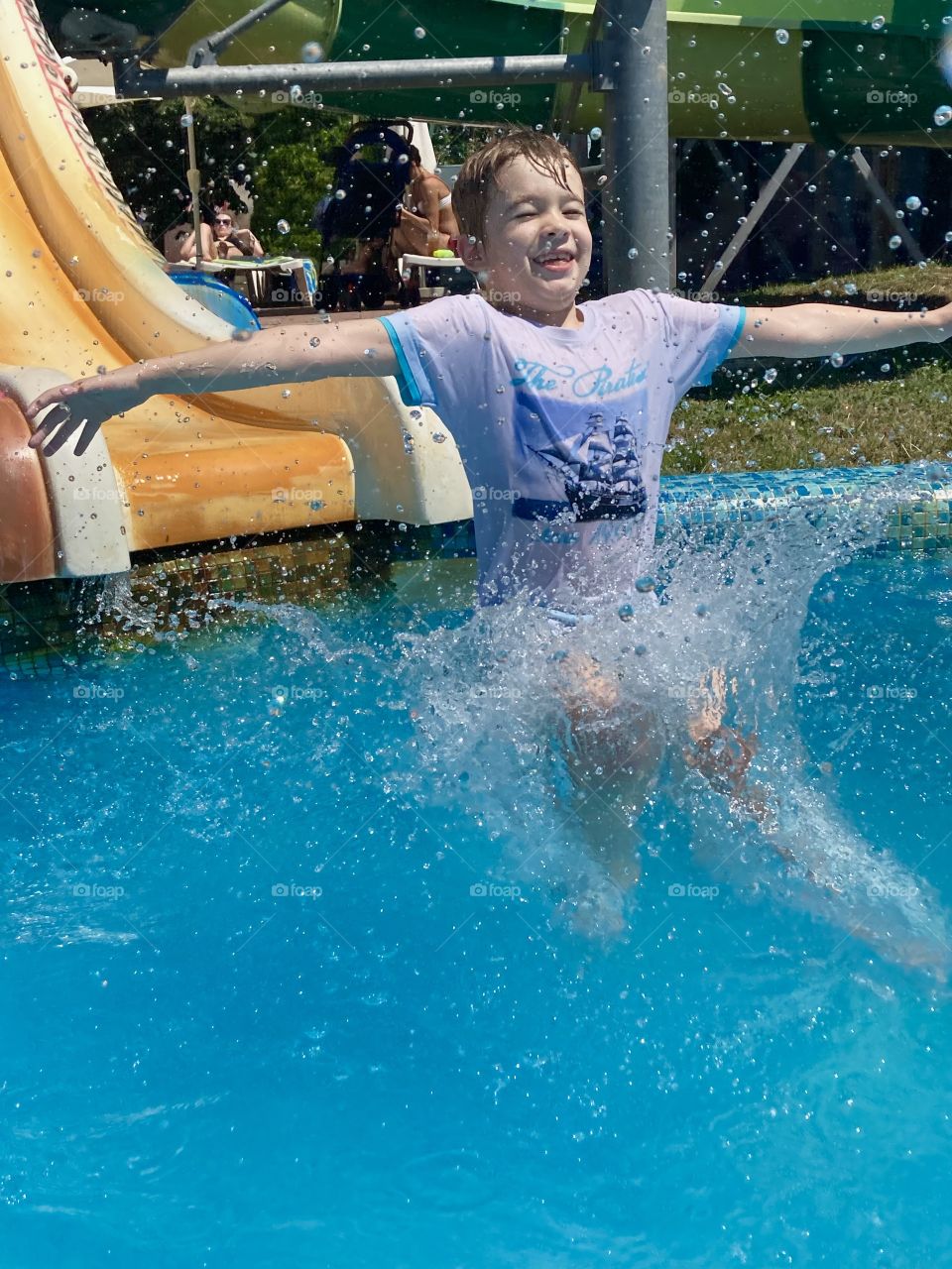 Boy in aqua-park  jumps into the water 