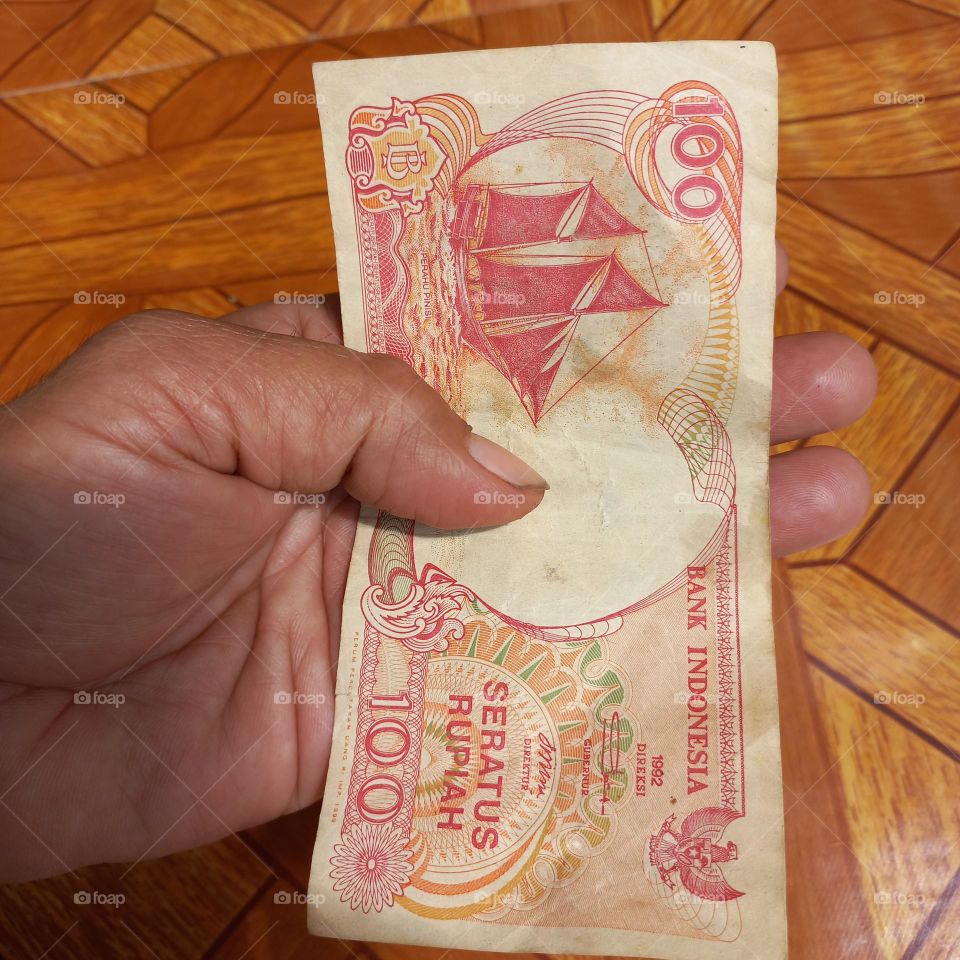Old one hundred rupiah banknotes in hand