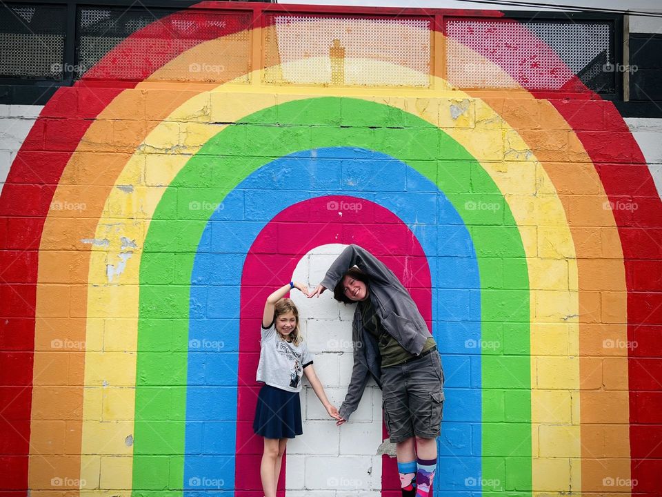 My kids posing in front of some rainbow wall art