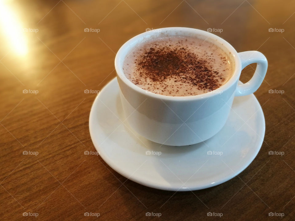 A cup of hot chocolate on wood brown table