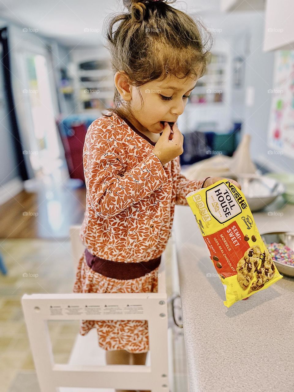 Toddler girl eats chocolate chips out of bag, sneaking chocolate chips out of bag while baking with mommy, baking with toddlers, making chocolate chip cookies, toddlers in the kitchen, Nestle Toll House chocolate chips