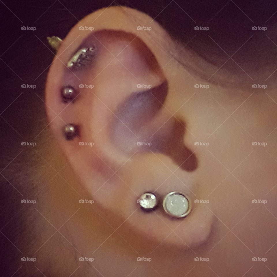 ear piercings on ear lobes and cartilage along with patterned studs very picturesque