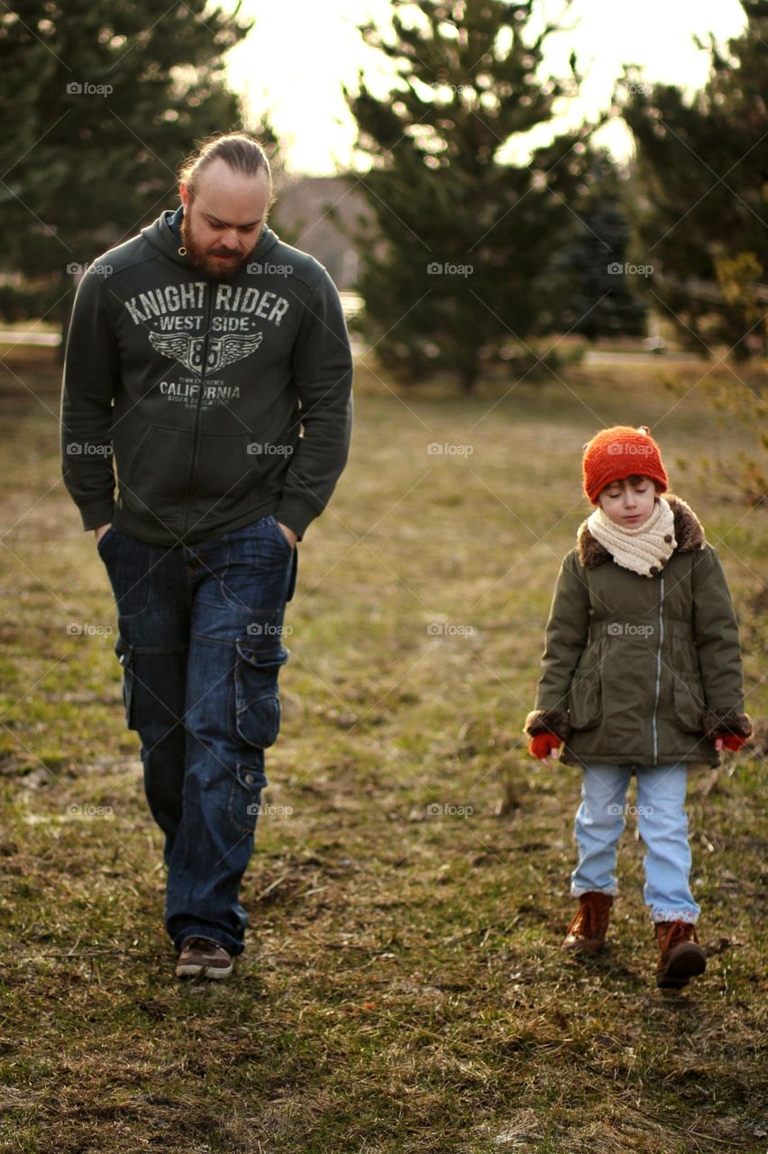 Dad and daughter are walking in the autumn park