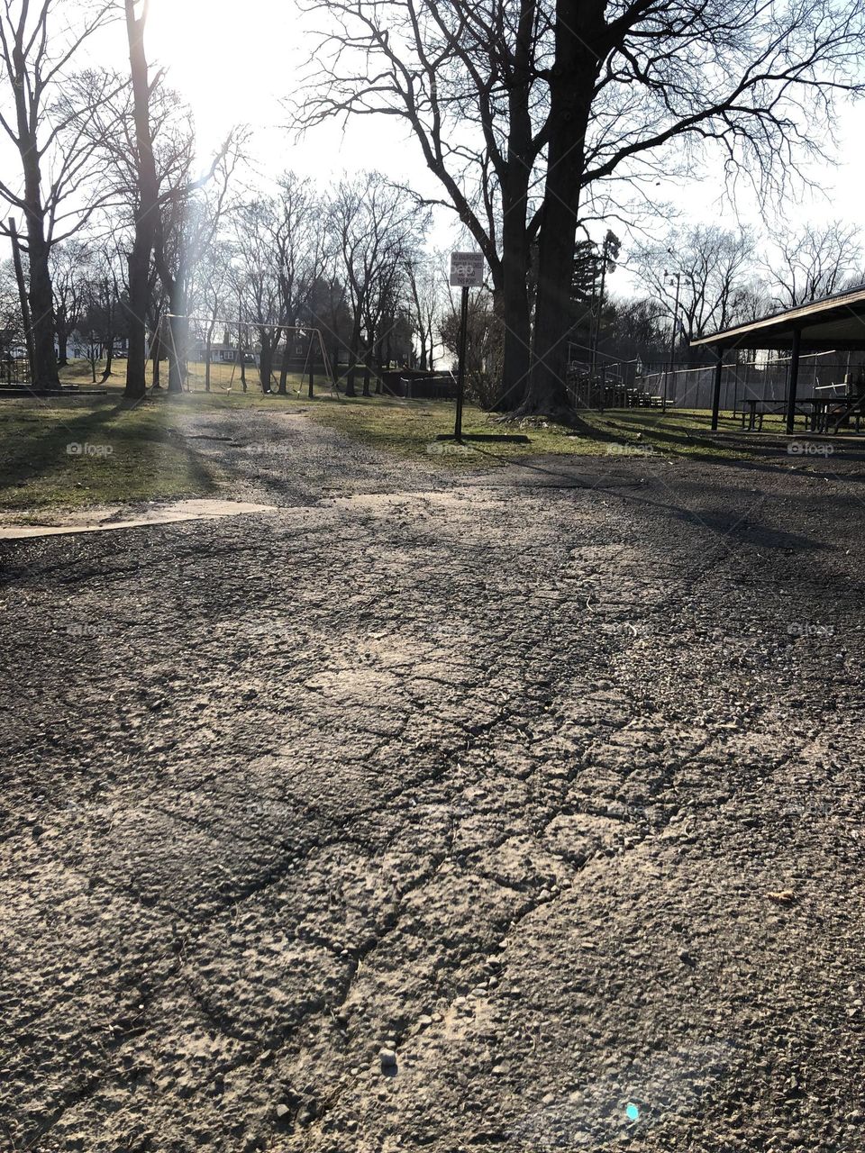 Cracks in the pavement make a very dry landscaping picture with a beam of sunlight in the back