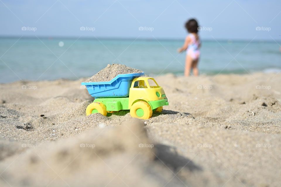 truck filled with golden sand on the beach