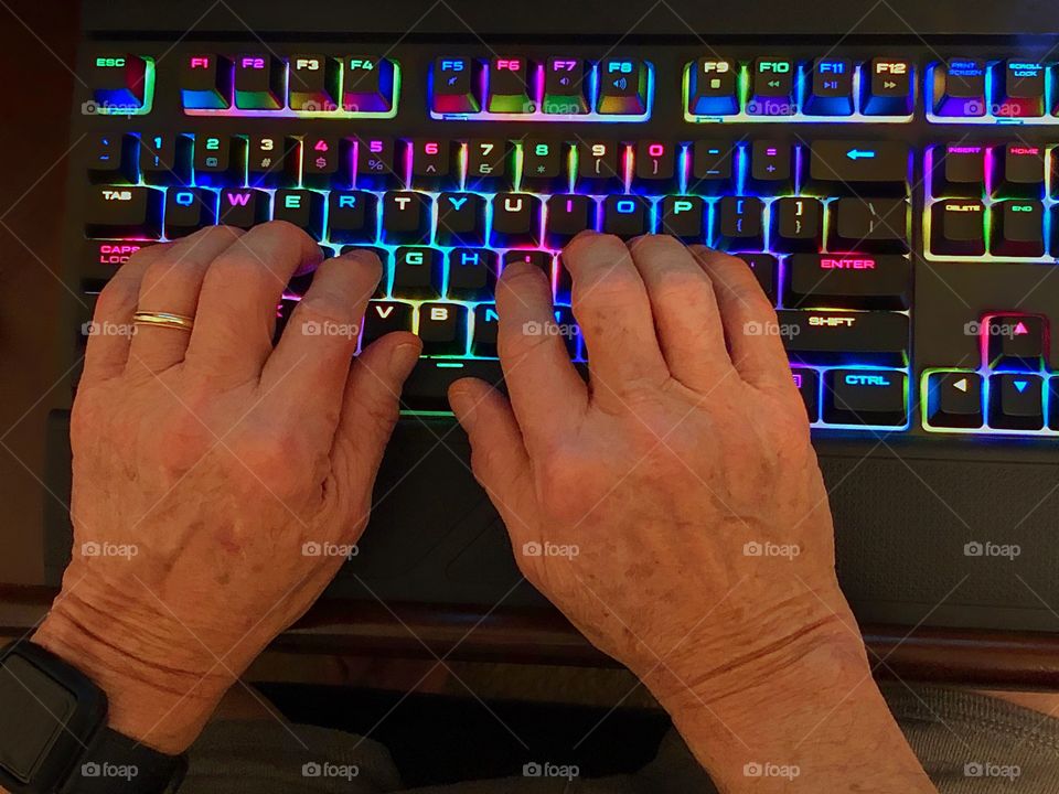 Typing on a multicolored keyboard.