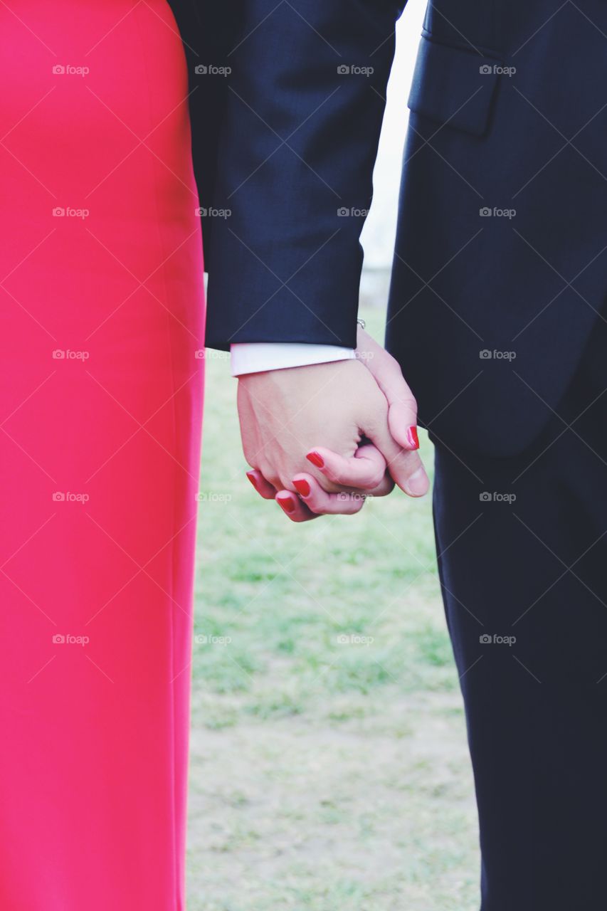 Close-up of bride and bridegroom holding hands
