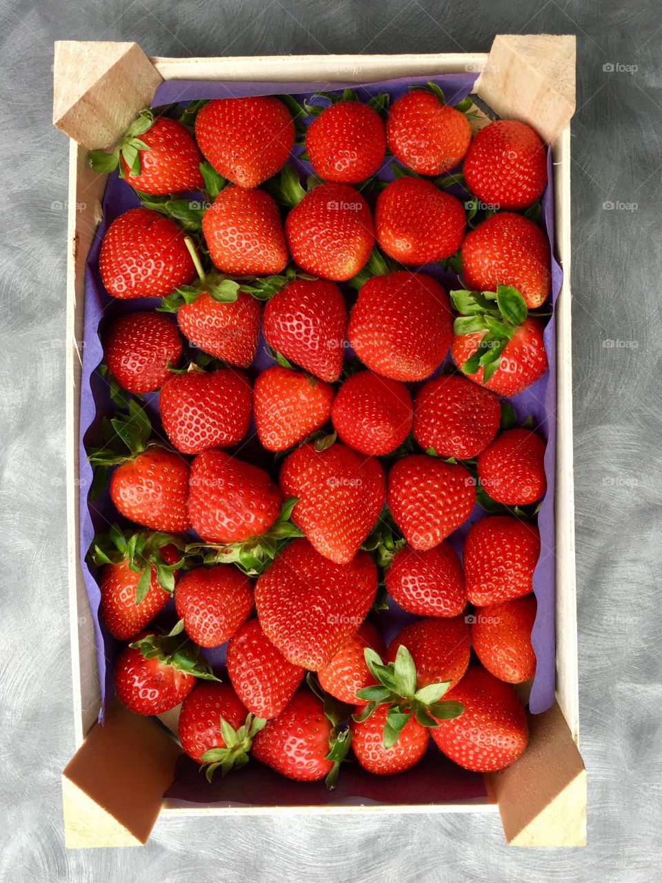 plan view of a mini-box of strawberries on a mottled gray base