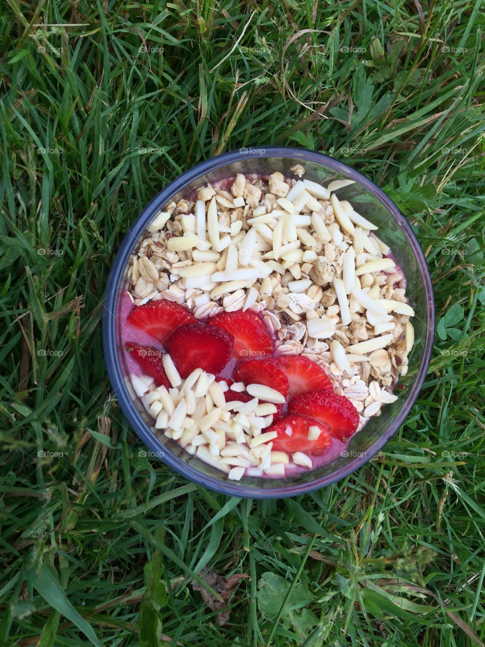Smoothies bowl with granola, almonds, oats & strawberries