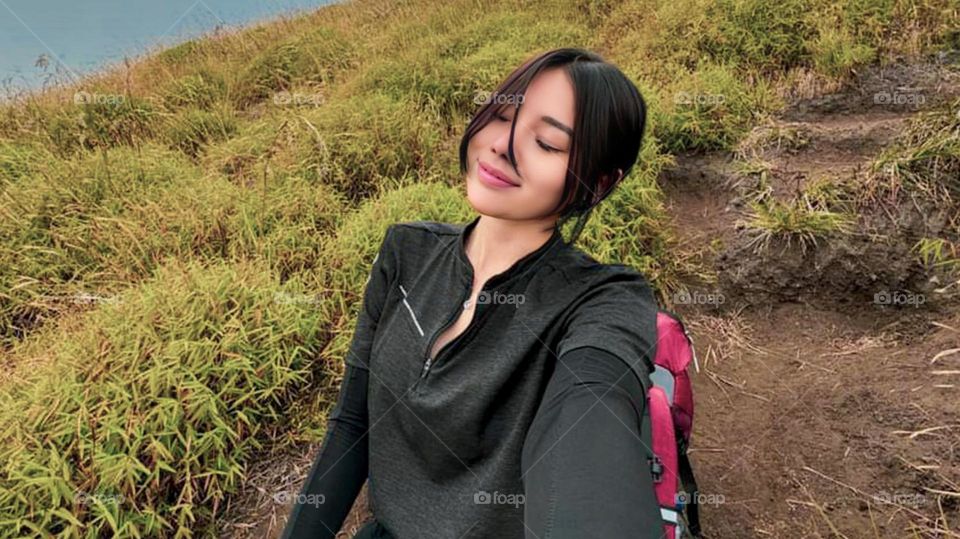 Portrait of a young woman smiling on a hillside