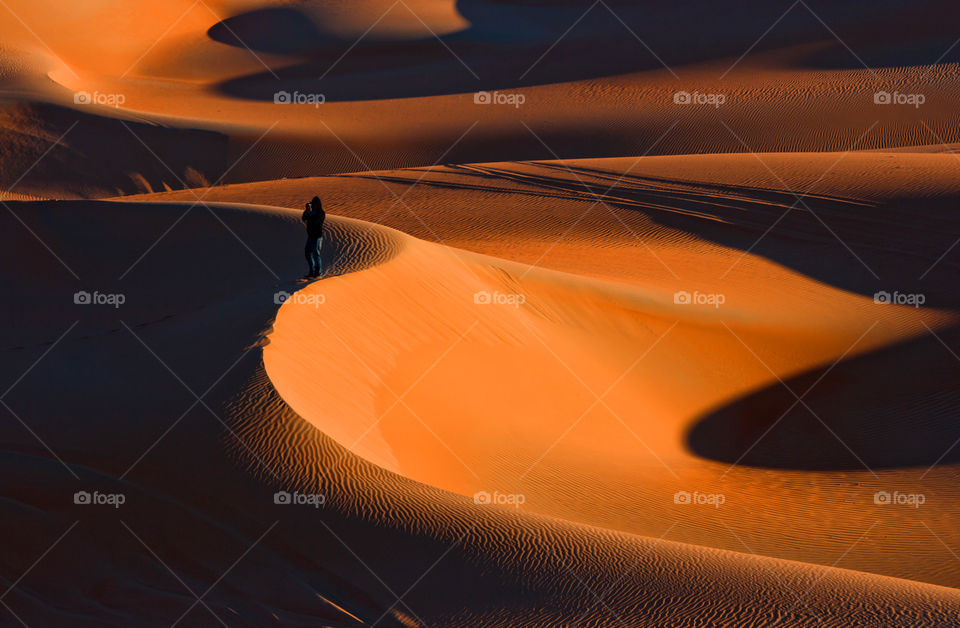 Silhouette of man on the top of the sand dune