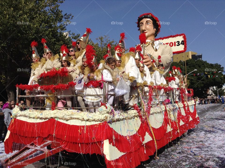 People riding on a float in a carnival parade.  Limassol carnival.