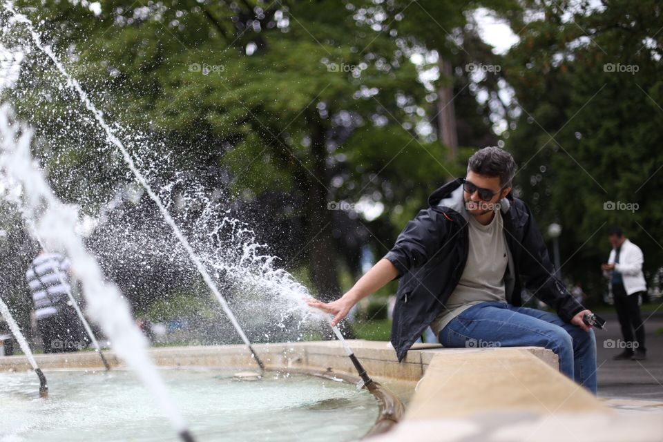 Man playing in fountain