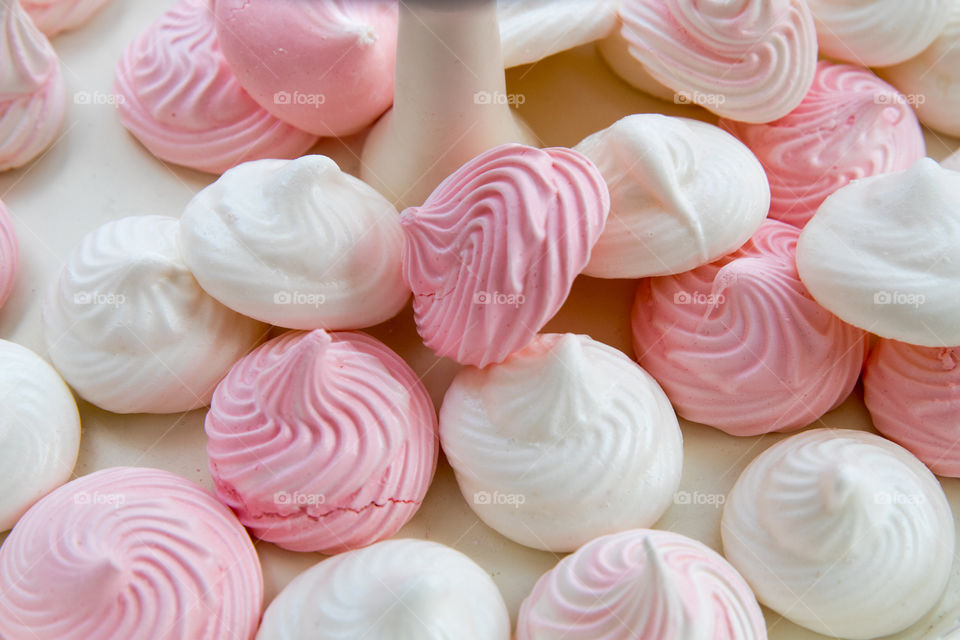 Dessert with white and pink meringue cakes.