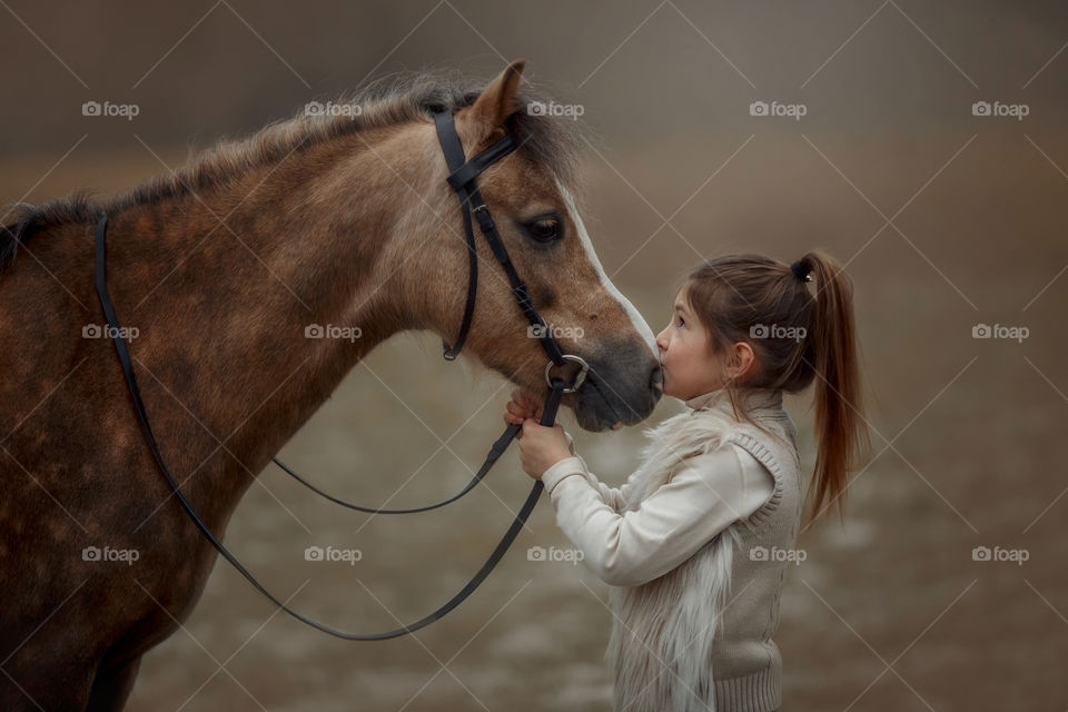 Portrait of little girl with  horse