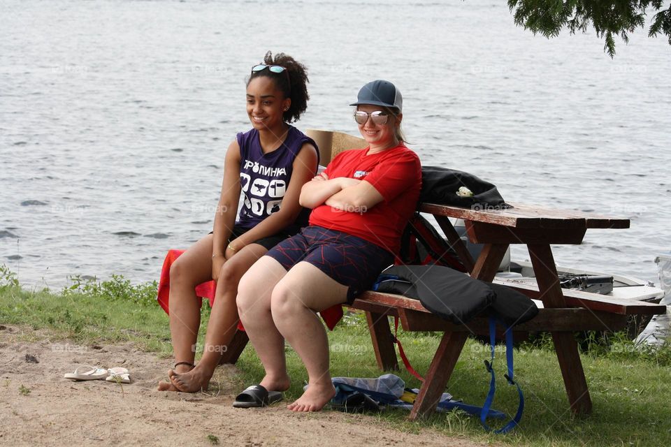 Two young women by the picnic table on the beach