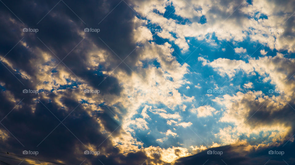 Large clouds float across the sunset sky like sails.