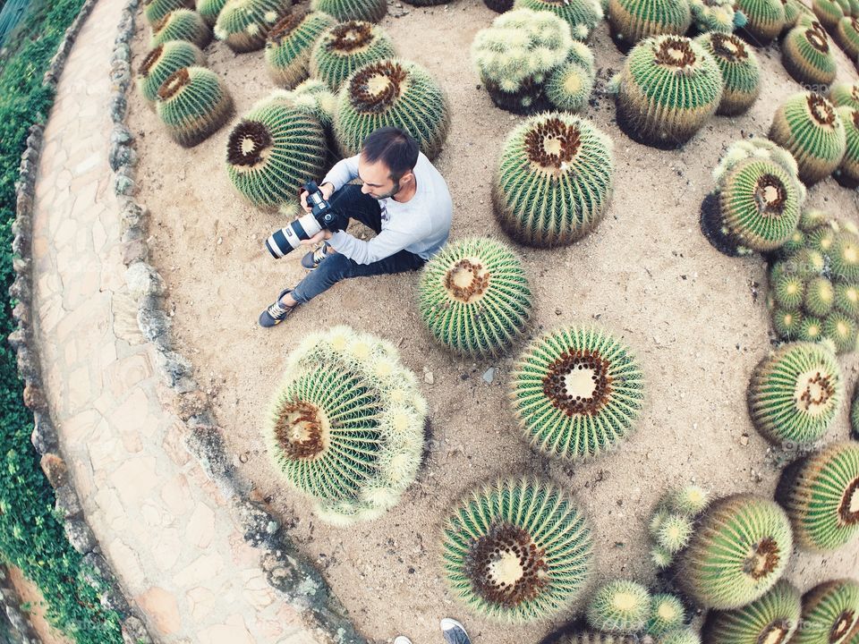 Photographer camouflaged in cacti
