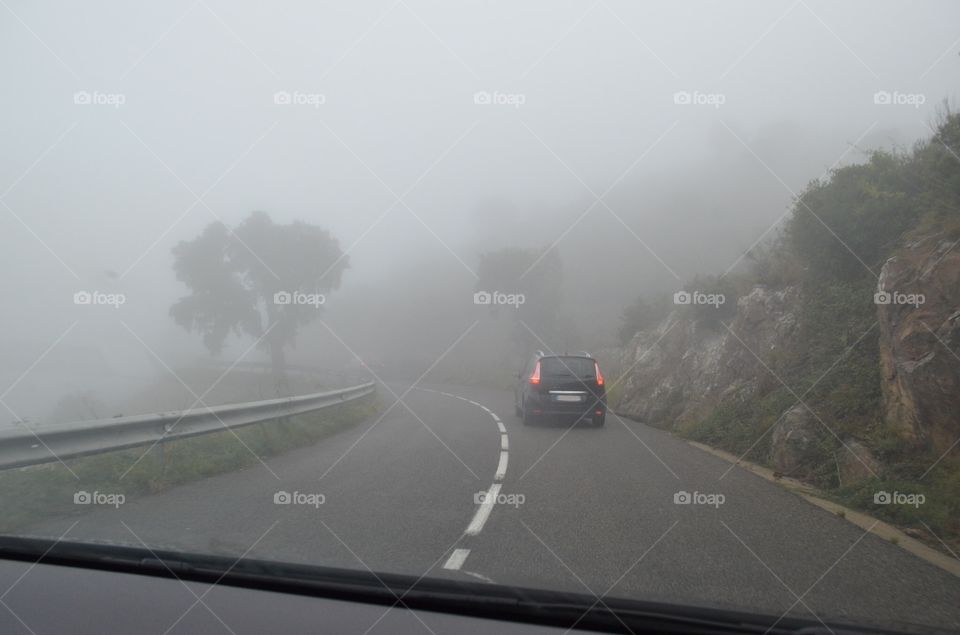 Driving into the mist. A small car driving into the mist 