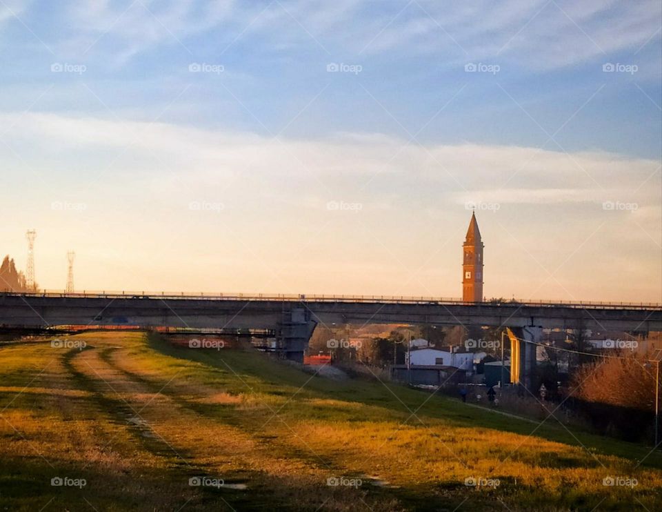 Outskirts of Occhiobello (Italy).  Endless fields, a small settlement, neat houses and a church tower