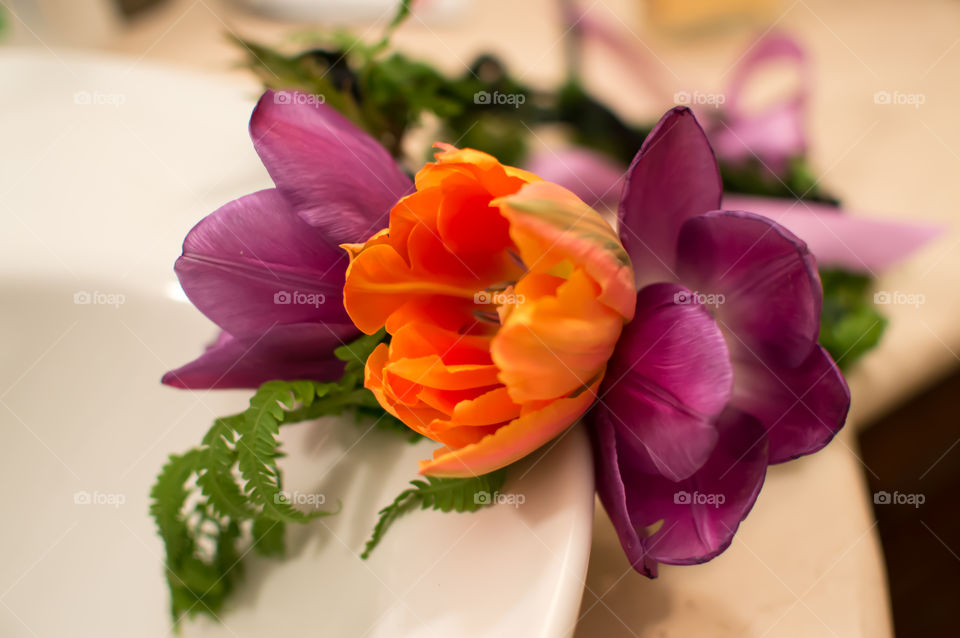 Flower garland on woman's vanity ready to wear for special occasion celebration or wedding with bright colorful tulips forming butterfly bow design on crown