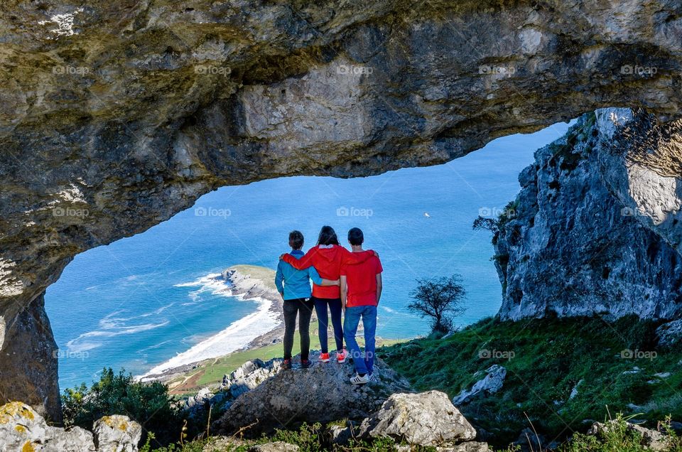 Family contemplates scenic view from a huge hole in the top of a mountain in Spain