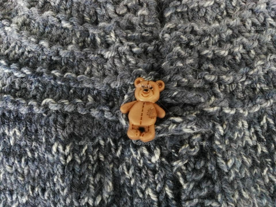 Bear button on hand-knit sweater