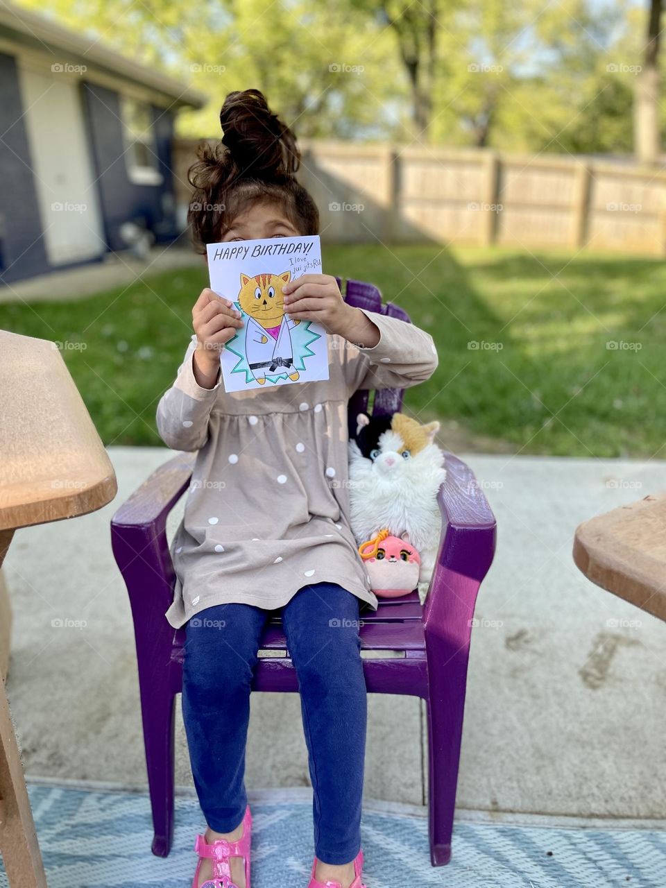 Little girl shows off birthday card, little girl happy about card, little girl excited about birthday party