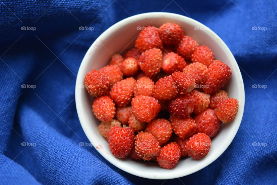 red strawberries on a plate tasty healthy summer food blue background