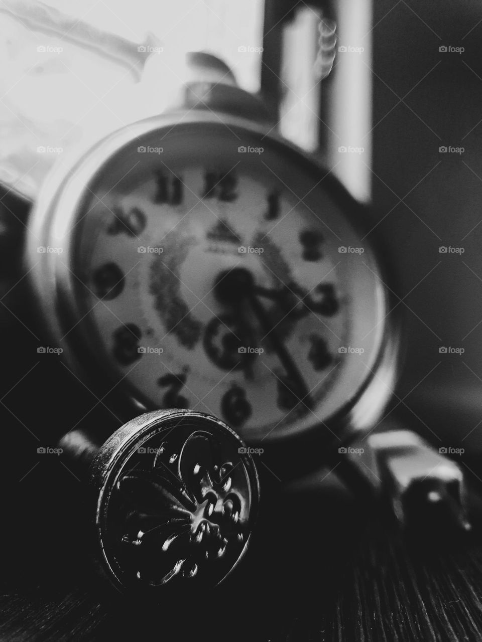 This vintage picture shows an old clock next to a royal stamp.