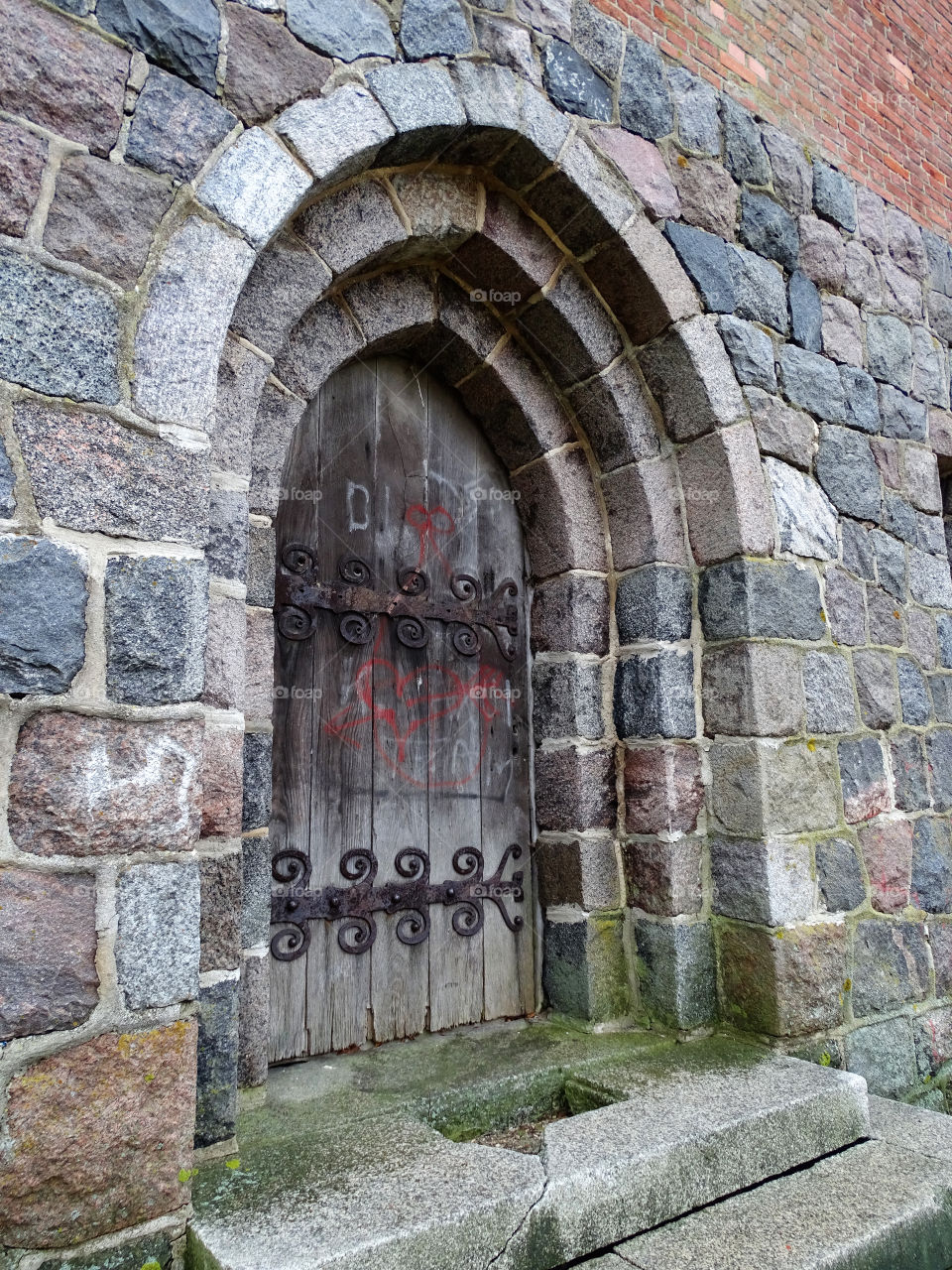 ancient wooden door in a wall of stones
