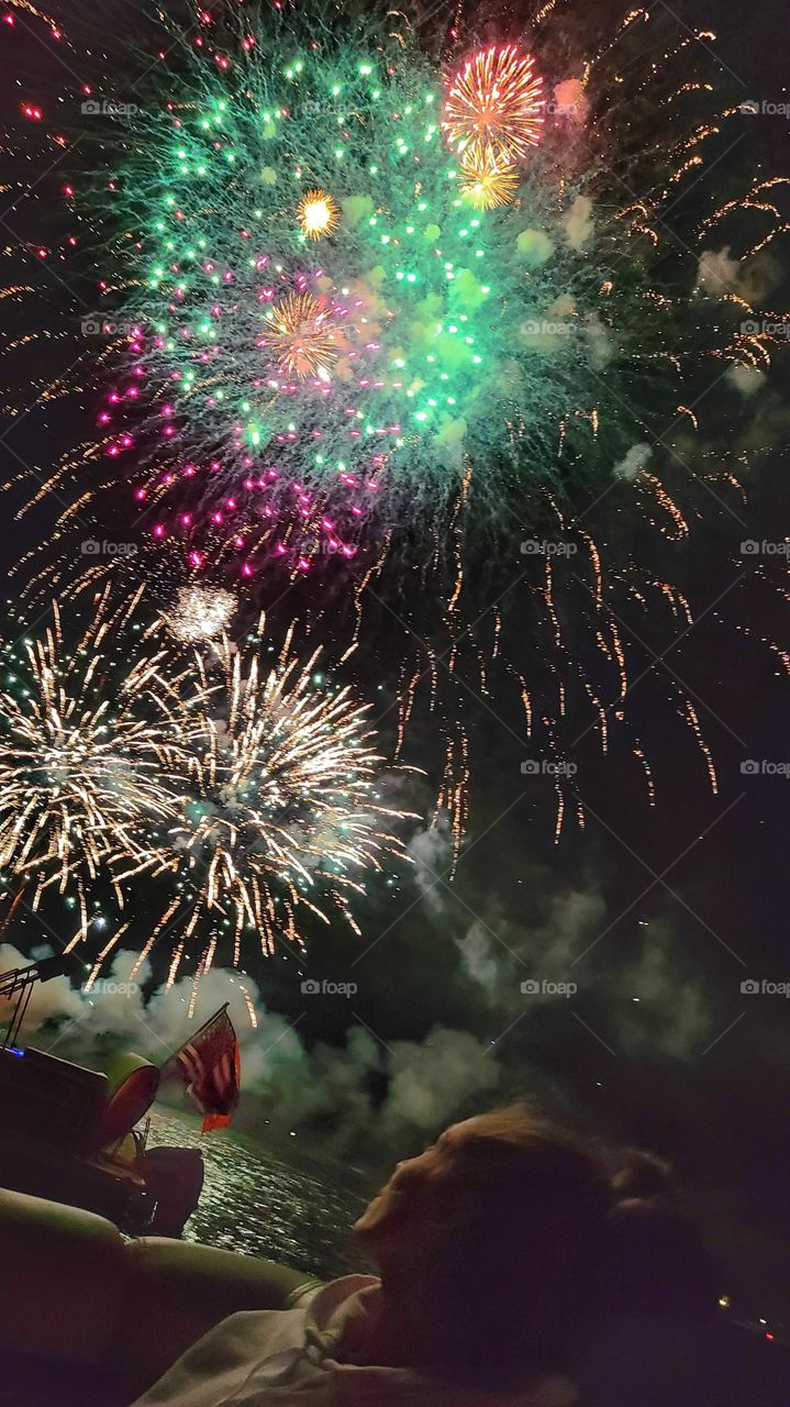 woman watches fireworks American flag