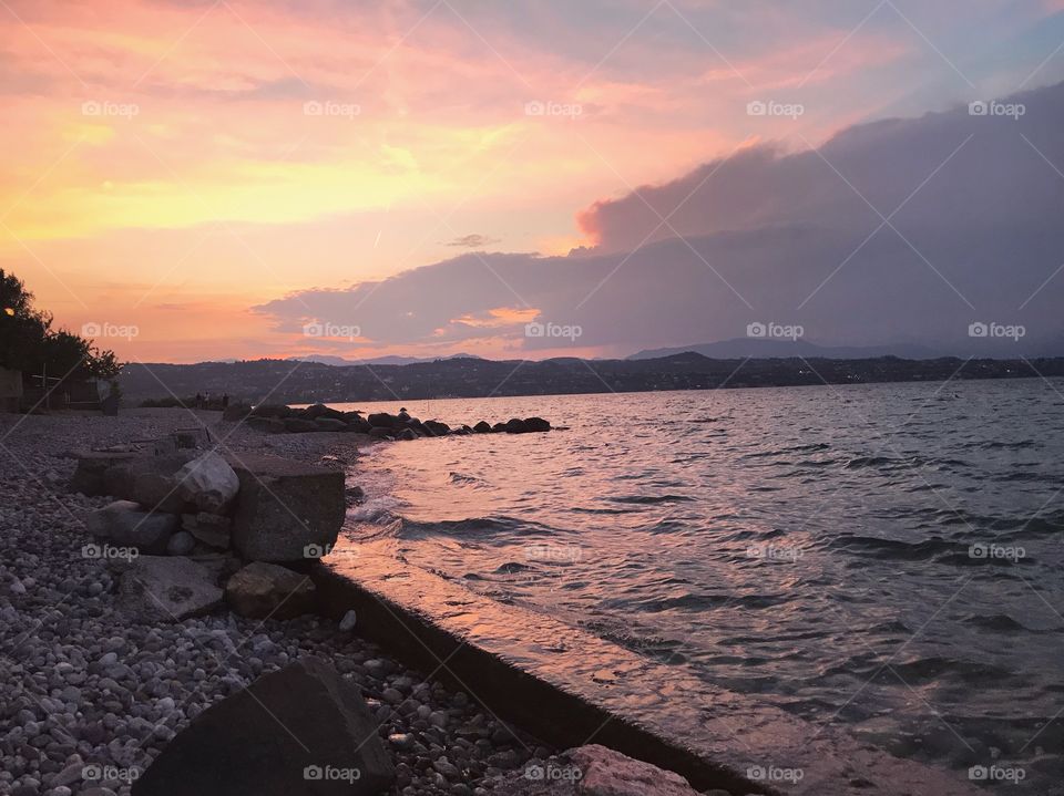 orange sky at sunset,color reflection on the water looks so beautiful,many large and small rocks