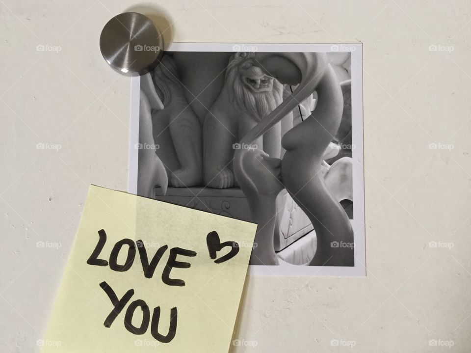 Post it saying love you. Marble man kissing stomach of woman