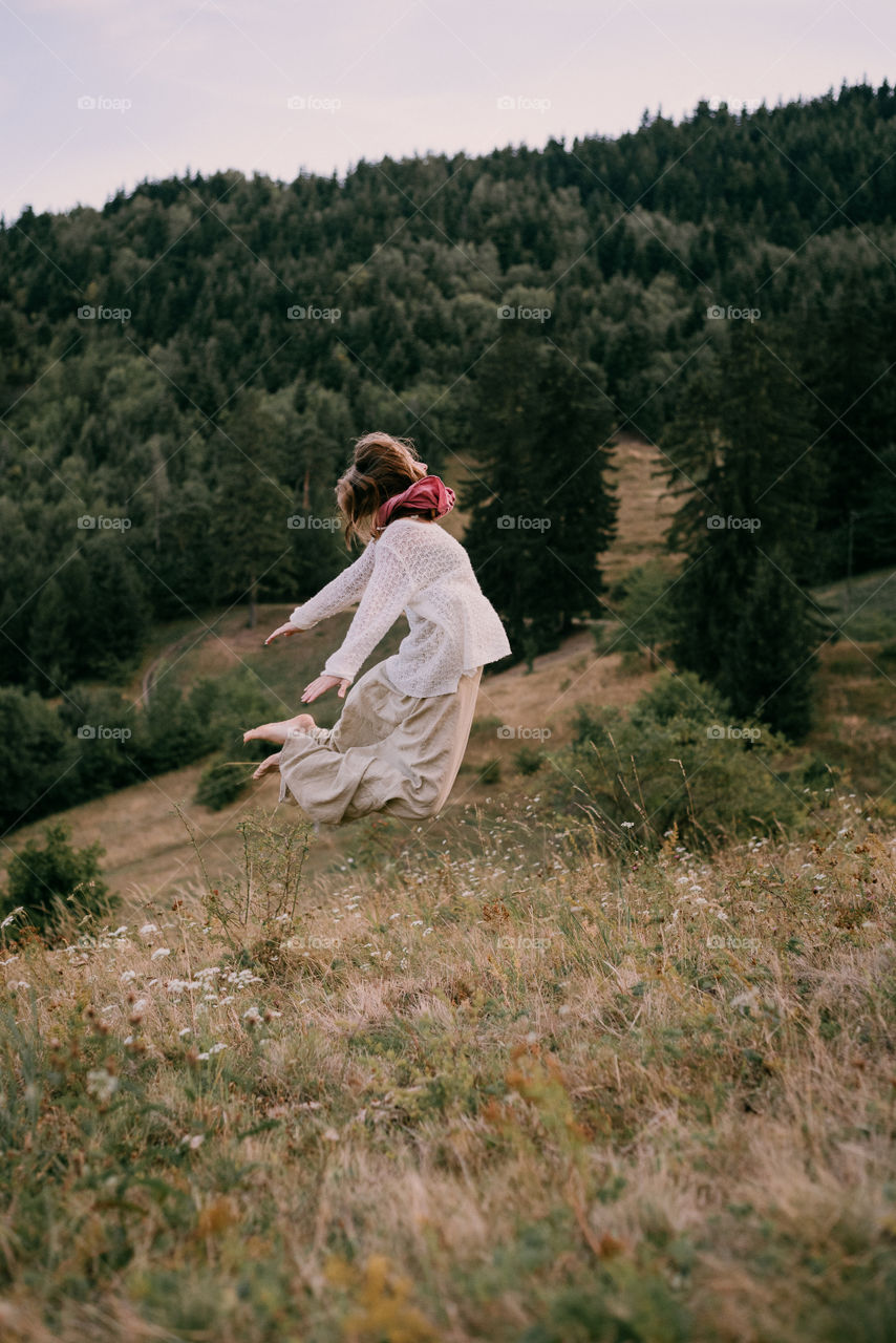 Woman jumping. Nature. Meadow, forest, trees. Green living, happy living. Live simple.